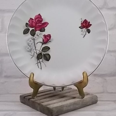 Assiette plate, en faïence Blanche, motif sérigraphié de Roses, bordure à facette festonnée souligné d'un liseré en dorure.