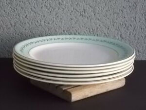 Assiette plate "Mogador", en demi-porcelaine Blanche et Verte. Motif de frise de feuillage en dorure. De la faïencerie de K & G Lunéville