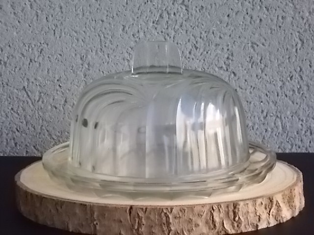 Cloche sur plateau en verre translucide moulé pressé. Forme Dôme, motif en relief de drapé, poignée plate facetté.