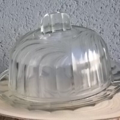 Cloche sur plateau en verre translucide moulé pressé. Forme Dôme, motif en relief de drapé, poignée plate facetté.