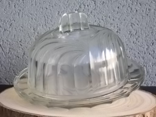 Cloche sur plateau en verre translucide moulé pressé. Forme Dôme, motif en relief de drapé, poignée plate facetté.