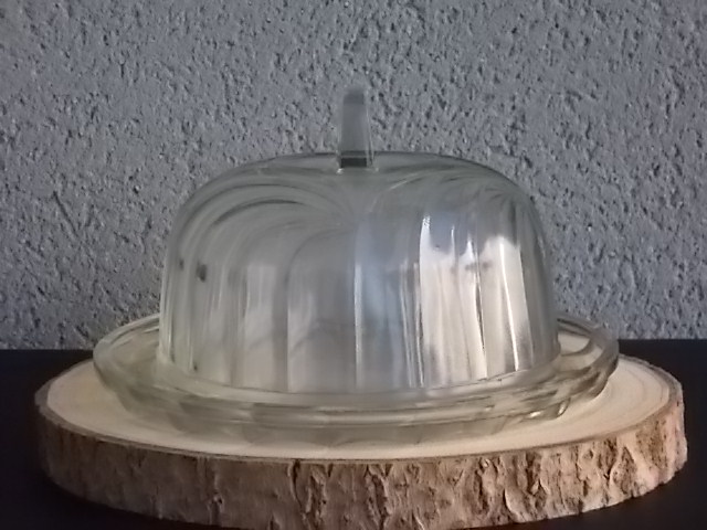 Cloche sur plateau en verre translucide moulé pressé. Forme Dôme, motif en relief de drapé, poignée plate facetté.