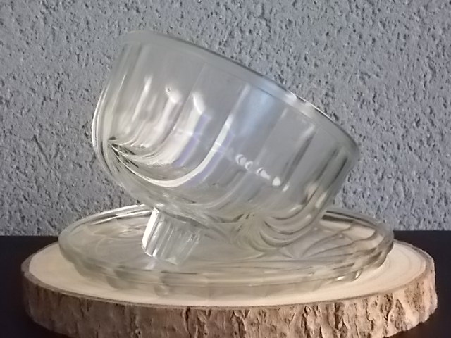 Cloche sur plateau en verre translucide moulé pressé. Forme Dôme, motif en relief de drapé, poignée plate facetté.