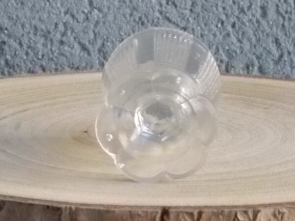Coquetier à pied en verre épais translucide soufflé moulé. Décors alterné de bande lisse et double stries. Pied en quartier formant fleur.