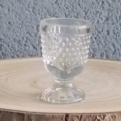 Coquetier piédouche en verre épais soufflé moulé translucide. Décors Perle de verre. Rebord lisse, cotes plates dessus pied.