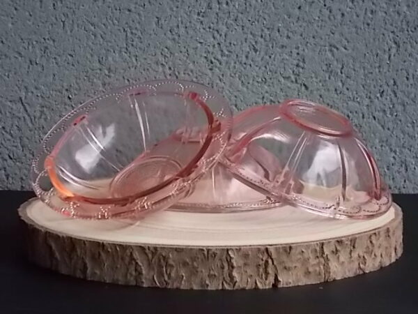 Coupelle en verre teinté Rose Saumoné, moulé pressé. Bol à rebord perlé plat avec effet piliers de soutient. Base fond cercles entrelacés perlés.