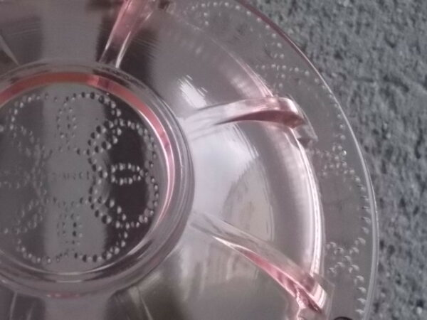 Coupelle en verre teinté Rose Saumoné, moulé pressé. Bol à rebord perlé plat avec effet piliers de soutient. Base fond cercles entrelacés perlés.