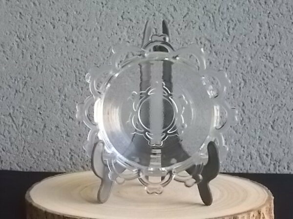 Coupelle ronde en verre translucide à bordure plate ajourée, moulé pressé. Coté biaisé, fond effet martelé avec motif forme de la coupelle.