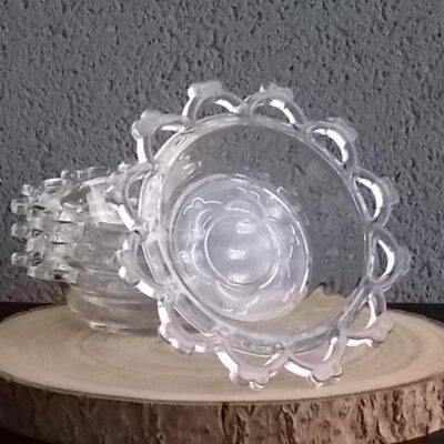 Coupelle ronde en verre translucide à bordure plate ajourée, moulé pressé. Coté biaisé, fond effet martelé avec motif forme de la coupelle.