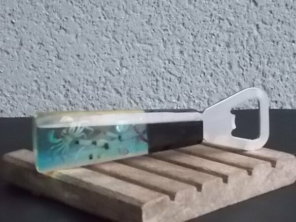 Décapsuleur manche en Résine avec inclusion de Coquillages, Etoile de Mer, Crabe, plantes aquatiques et Paillettes. En Inox 18/8 de la Marque Acero