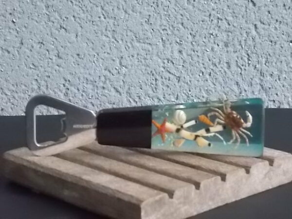 Décapsuleur manche en Résine avec inclusion de Coquillages, Etoile de Mer, Crabe, plantes aquatiques et Paillettes. En Inox 18/8 de la Marque Acero