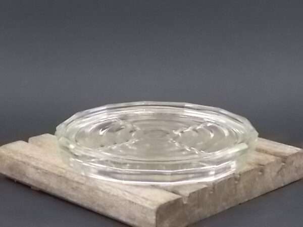 Dessous de bouteille, en verre épais, moulé pressé. Forme ronde à pans coupés. De la verrerie BVB France.