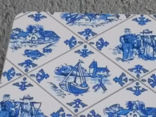 Dessous de plat "Hollande" en Formica sur aggloméré, à motif Bleu sur fond Blanc. Quatre pieds plastique Blanc en demi cercle