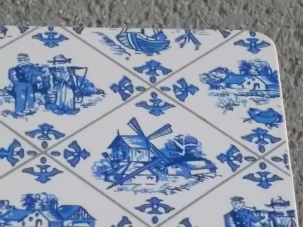 Dessous de plat "Hollande" en Formica sur aggloméré, à motif Bleu sur fond Blanc. Quatre pieds plastique Blanc en demi cercle