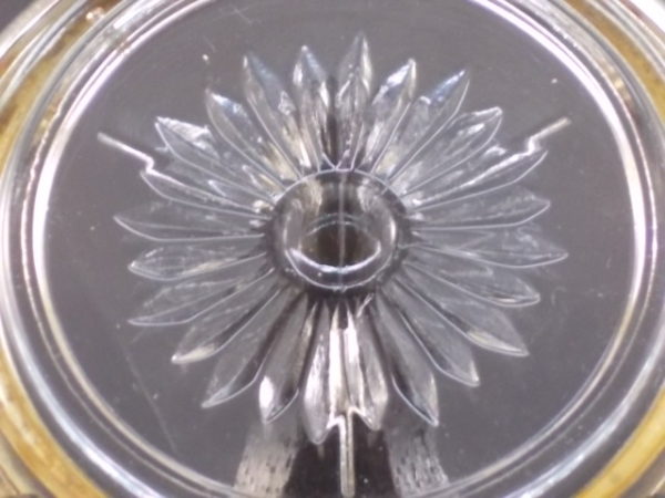 Dessous de verre "Marguerite" en verre moulé, pressé à motif floral. Cerclage en métal Argent strié en bordure.