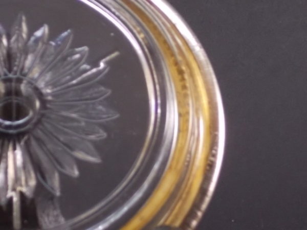 Dessous de verre "Marguerite" en verre moulé, pressé à motif floral. Cerclage en métal Argent strié en bordure.
