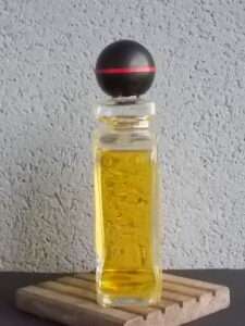 Eau de Cologne 750 ml, flacon en verre. Forme carré, angles arrondis sur socle. Etiquette plastifiée carrée. Bouchon à vis forme Boule. De la maison Grès Paris