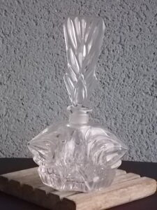 Flacon à Parfum, en verre moulé pressé taillé. Forme hexagonale, bouchon plat. Col et bouchon émerisé. Base étoilé.