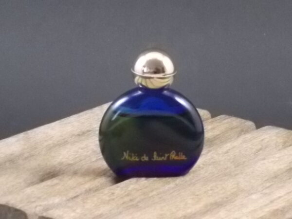 "Nikki de Saint Phalle" miniature EdT 6 ml. Flacon en verre teinté Bleu. Bouchon en plastique Doré. Parfum crée en 1984. De Nikki de Saint Phalle Paris
