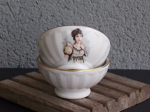 Petit bol piédouche en porcelaine Blanche à godron. Motif représentant "Napoléon et Joséphine" et liseré en dorure.