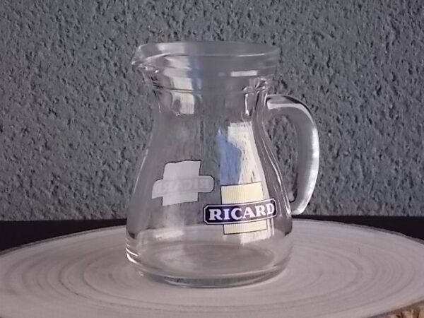 Petit pichet "Ricard" en verre moulé translucide. Corps pansu, poignée courbe et bec verseur. Contenant 25 cl. Du groupe Cerve Italy
