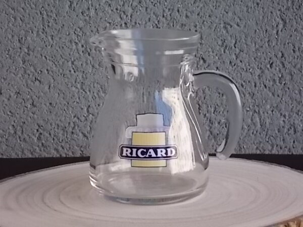 Petit pichet "Ricard" en verre moulé translucide. Corps pansu, poignée courbe et bec verseur. Contenant 25 cl. Du groupe Cerve Italy