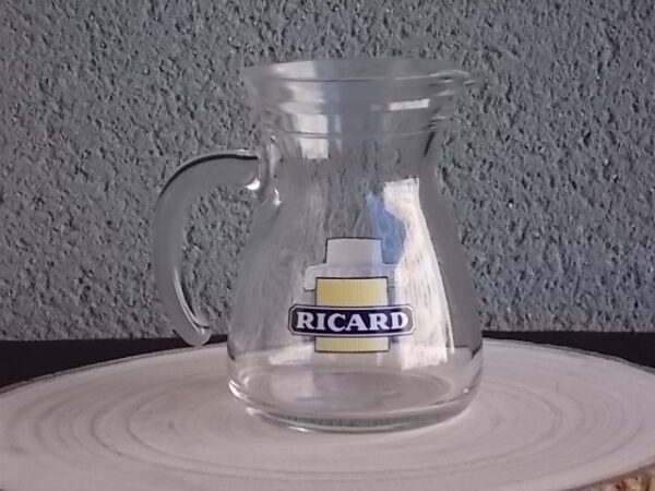 Petit pichet "Ricard" en verre moulé translucide. Corps pansu, poignée courbe et bec verseur. Contenant 25 cl. Du groupe Cerve Italy