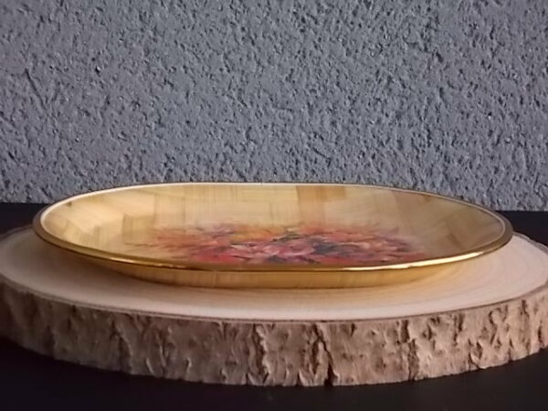 Petit plateau ovale creux, en tissage de feuille de Palmier vernissé, à décors imprimé fleurie. Bordure en cerclage de plastique Doré.