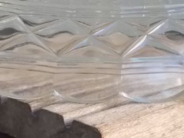 Petite coupe Ovale en verre épais moulé pressé. Décors bande frise losange entre 3 stries, bordure festonnée et fond Etoilé