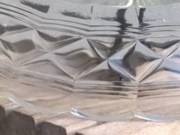 Petite coupe Ovale en verre épais moulé pressé. Décors bande frise losange entre 3 stries, bordure festonnée et fond Etoilé