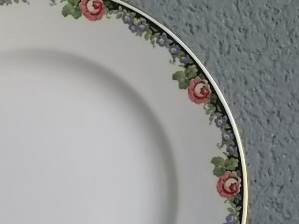 Plat creux rond "3984", en faience Blanche. Motif floral de fleurs Rose et Bleu alternée et feuillage Vert sur fond Noir. Liseré en dorure sur bordure. De la faïencerie de Sarreguemines France.