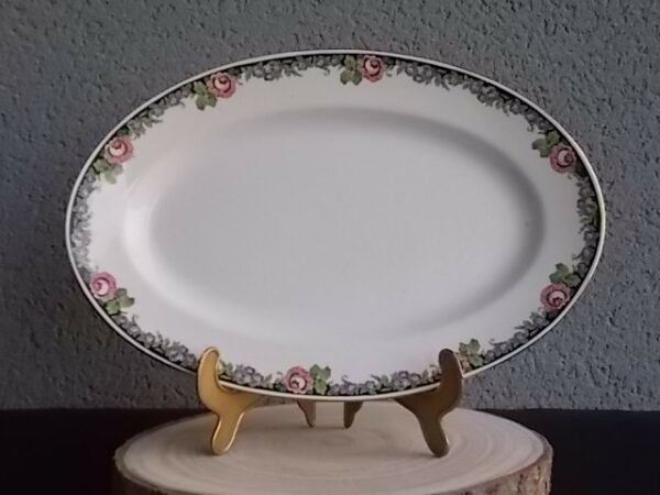 Plat ovale creux "3984", en faience Blanche. Motif floral de fleurs Rose et Bleu alternée et feuillage Vert sur fond Noir. Liseré en dorure sur bordure. De la faïencerie de Sarreguemines France.