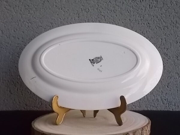 Plat ovale creux "3984", en faience Blanche. Motif floral de fleurs Rose et Bleu alternée et feuillage Vert sur fond Noir. Liseré en dorure sur bordure. De la faïencerie de Sarreguemines France.