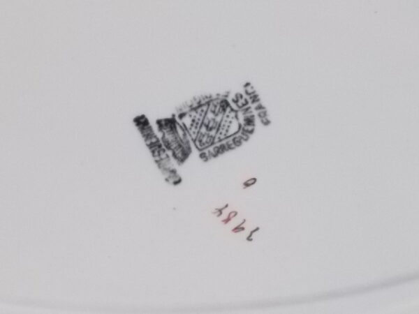 Plat ovale creux "3984", en faience Blanche. Motif floral de fleurs Rose et Bleu alternée et feuillage Vert sur fond Noir. Liseré en dorure sur bordure. De la faïencerie de Sarreguemines France.