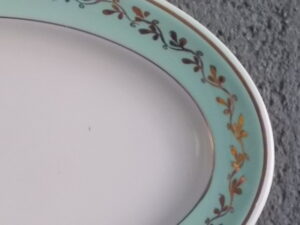 Ravier ovale "Mogador", en demi-porcelaine Blanche et Verte. Motif de frise de feuillage en dorure. De la faïencerie de K & G Lunéville