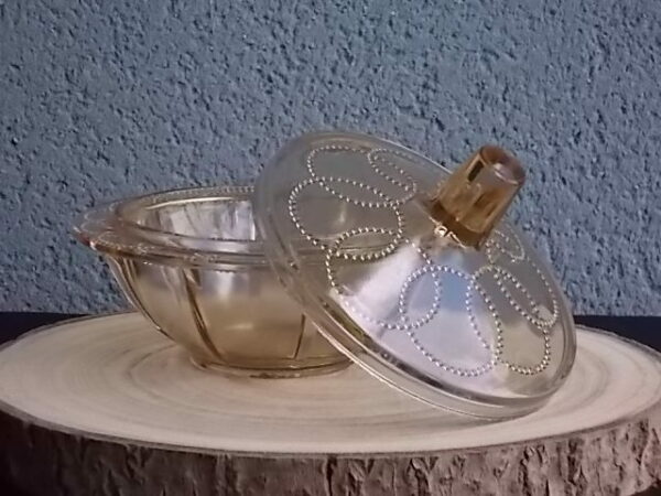 Sucrier couvert en verre teinté Ambre, moulé pressé. Bol à rebord perlé plat avec effet piliers de soutient. Base fond cercles entrelacés perlés. Couvercle Dôme, bouton conique.