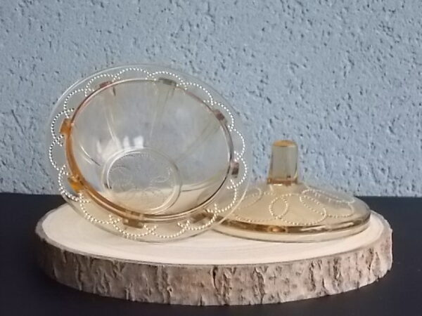 Sucrier couvert en verre teinté Ambre, moulé pressé. Bol à rebord perlé plat avec effet piliers de soutient. Base fond cercles entrelacés perlés. Couvercle Dôme, bouton conique.
