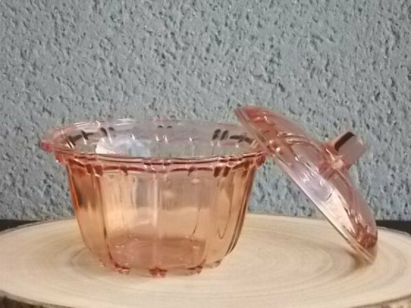 Sucrier couvert en verre teinté Rose Saumoné, moulé pressé. Bol tour cannelé nervuré. Rebord festonné perlé. Base fond Soleil pieds perlés. Couvercle Dôme, bouton conique.