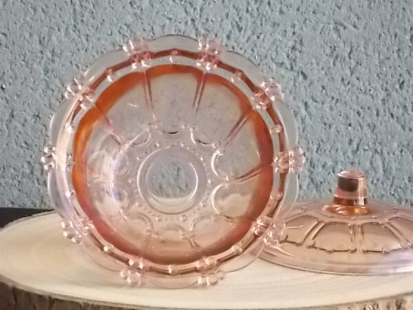 Sucrier couvert en verre teinté Rose Saumoné, moulé pressé. Bol tour cannelé nervuré. Rebord festonné perlé. Base fond Soleil pieds perlés. Couvercle Dôme, bouton conique.