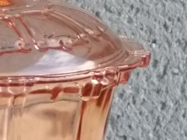 Sucrier couvert en verre teinté Rose Saumoné, moulé pressé. Bol tour cannelé nervuré. Rebord festonné perlé. Base fond Soleil pieds perlés. Couvercle Dôme, bouton conique.
