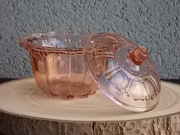 Sucrier couvert en verre teinté Rose Saumoné, moulé pressé. Bol tour cannelé nervuré. Rebord festonné perlé. Base fond Soleil pieds perlés. Couvercle Dôme, bouton conique.