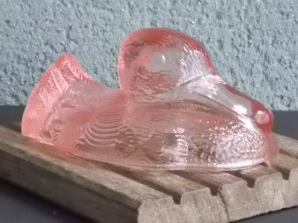 Terrine "Canard" en verre teinté Rose moulé pressé. Décors sculpté motif Plumage. Forme Ovale, fermeture par emboitement.
