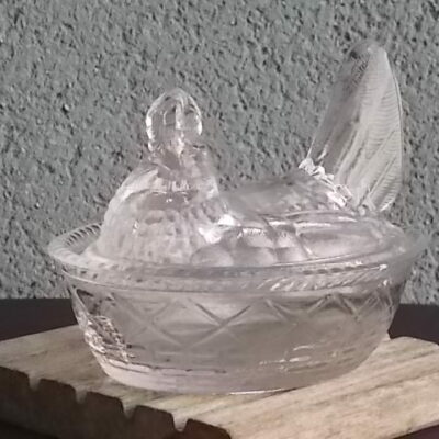 Terrine "Poule Panier" en verre translucide épais moulé pressé. Forme Ovale, représentant une Poule qui couve dans un Panier.