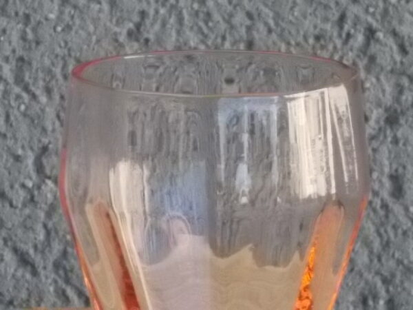 Verre à Apéritif "facetté" légèrement vrillé en verre teinté Rose Saumoné. Forme évasé sur 2/3, resserré au buvant, base effet piédouche.