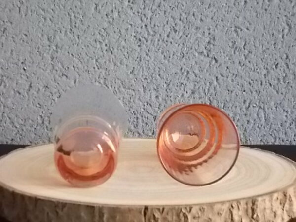 Verre à Eau, en verre soufflé teinté Rose Saumoné "Cannelé". Forme évasé avec effet bourrelet au 1/4 base. Piédouche épais bombé.