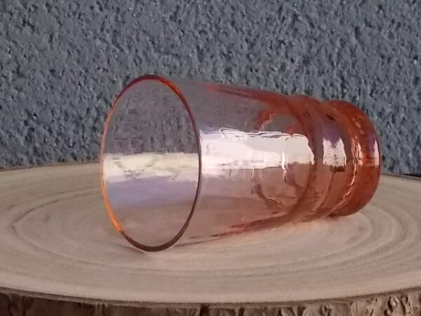 Verre à Eau, en verre soufflé teinté Rose Saumoné "Cannelé". Forme évasé avec effet bourrelet au 1/4 base. Piédouche épais bombé.