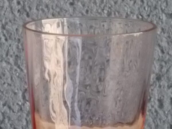 Verre à Eau, en verre soufflé teinté Rose Saumoné "Cannelé". Forme évasé avec effet bourrelet au 1/4 base. Piédouche épais bombé.