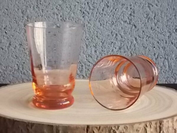 Verre à Eau, en verre soufflé teinté Rose Saumoné "Facetté". Forme évasé avec effet bourrelet au 1/4 base. Piédouche épais bombé.