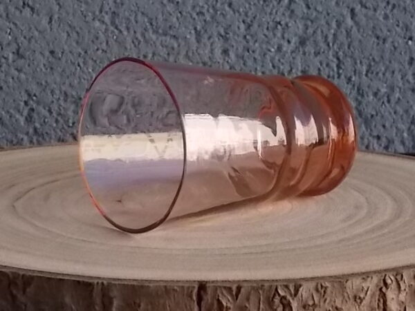 Verre à Eau, en verre soufflé teinté Rose Saumoné "Facetté". Forme évasé avec effet bourrelet au 1/4 base. Piédouche épais bombé.
