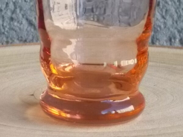 Verre à Eau, en verre soufflé teinté Rose Saumoné "Facetté". Forme évasé avec effet bourrelet au 1/4 base. Piédouche épais bombé.